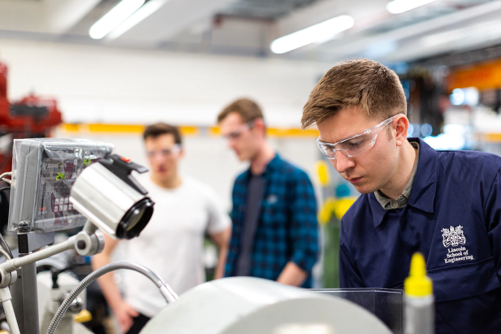Engenheiro programando um sistema de automação industrial numa célula robótica
